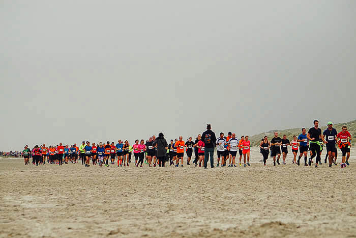 Lopers van de halve marathon op het strand tijdens de Berenloop van 2015